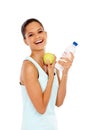 She enjoys healthy food. Portrait of a beautiful young woman holding a bottle of water and an apple. Royalty Free Stock Photo