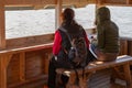 Two women communicate with each other and look at the water. Sitting on the observation tower. Back view