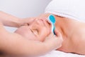 Enlarged photo of senior woman and face massage with cosmetic massager. Skin care, spa and beauty concept.