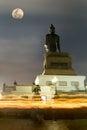 Enormous Buddha statue under moonlight