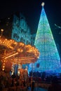 Enormous christmas tree in Vigo near a carousel at night Royalty Free Stock Photo