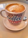 The `with enough coffee anything is possible` coffee mug for comedy and education purposes. White mug filled with cappucchino Royalty Free Stock Photo
