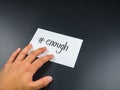Enough hashtag on card paper with hand on black background Royalty Free Stock Photo