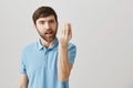 Enough of that, you make me mad. Portrait of slender ordinary european guy showing italian gesture with raised hand