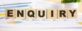 ENQUIRY word on wooden cubes. The background is a business graphs. Business and finance concept