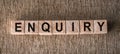 ENQUIRY word written on wooden blocks on a brown background