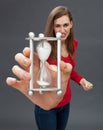 Enraged beautiful young woman holding a stressful hour glass