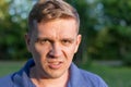 Enraged infuriated man baring his teeth. Portrait of a young man on nature background. Emotion facial expression. Royalty Free Stock Photo