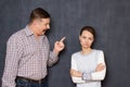 Enraged man is shouting and shaking finger while scolding woman