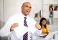 Enraged man tearing piece of paper in office