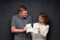 Enraged man and woman are tearing paper sheet