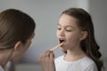 ENT doctor examining little girl throat during visit in clinic