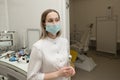 An ENT doctor in a modern ENT office of a hospital looks at the camera in a white coat and mask Royalty Free Stock Photo