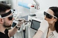 ENT doctor in protective glasses holding surgical laser and doing laser treatment inflammation of the nasal lining Royalty Free Stock Photo