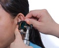 ENT physician checking patient's ear using otoscope with an inst