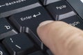 Enter key on a computer keyboard, a person presses a finger, close-up, selective focus Royalty Free Stock Photo