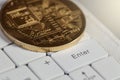 Enter key on white keyboard, golden bit coin laying on laptop keyboard Royalty Free Stock Photo