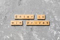 Enter to win prizes word written on wood block. Enter to win prizes text on cement table for your desing, Top view concept Royalty Free Stock Photo