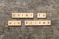 Enter to win prizes word written on wood block. Enter to win prizes text on cement table for your desing, Top view Royalty Free Stock Photo