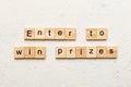 Enter to win prizes word written on wood block. Enter to win prizes text on cement table for your desing, Top view Royalty Free Stock Photo