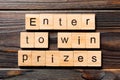 Enter to win prizes word written on wood block. Enter to win prizes text on wooden table for your desing, Top view concept Royalty Free Stock Photo