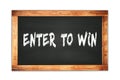 ENTER  TO  WIN text written on wooden frame school blackboard Royalty Free Stock Photo