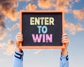 Enter To Win word on blackboard with hands are holding. Royalty Free Stock Photo