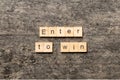 Enter To Win word written on wood block. Enter To Win text on cement table for your desing, concept Royalty Free Stock Photo