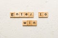 Enter To Win word written on wood block. Enter To Win text on cement table for your desing, concept Royalty Free Stock Photo