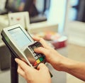 Enter your pin to complete your payment. Closeup shot of a person typing their pin number into a credit card machine at