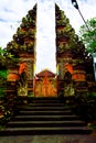 Stone red ancient gate to a sacred temple in Ubud, Bali for people to pray and worship Royalty Free Stock Photo