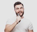 The entertainer. Young talking man holding microphone, Isolated on white background. Royalty Free Stock Photo