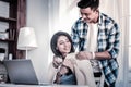 Caring young man covering his dark-haired girlfriend with plaid