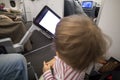 Entertainment on board the aircraft in flight. kid looking at white screen of copyspace airplane multimedia system