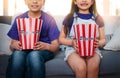 Entertainment thatll keep them on the edge of their seats. two unrecognizable young children sitting on a sofa and Royalty Free Stock Photo