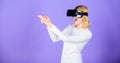 Enthralling interaction virtual reality. Woman head mounted display violet background. Virtual reality shooting gallery