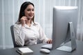 Enthusiastic asian call center with headset on her workplace portrait. Royalty Free Stock Photo