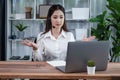 Enthusiastic asian call center with headset and microphone working on her laptop Royalty Free Stock Photo