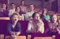 Enthusiastic audience attending movie night with popcorn