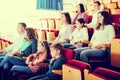 Enthusiastic audience eating popcorn and watching a movie