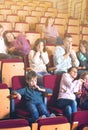 Enthusiastic audience eating popcorn and watching a movie