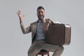 Enthusiastic bearded man holding briefcase on thigh and laughing Royalty Free Stock Photo
