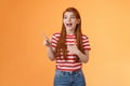 Enthusiastic cheerful redhead woman lively smiling laughing joyfully, enjoy watching copy space, look pointing upper