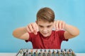 An enthusiastic child is about to tune a music mixing console