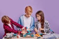 Enthusiastic concerned children assembling tech robots, future engineers