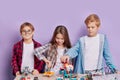 Enthusiastic concerned children assembling tech robots, future engineers