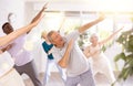 Elderly man performing dabbing during dance class with group