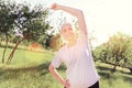 Enthusiastic elderly woman doing exercises outdoors