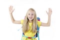 Enthusiastic elementary school girl posing with arms raised up, victorious. Royalty Free Stock Photo