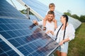 Enthusiastic father showing potential of alternative energy. Contemporary family looking at new solar station they